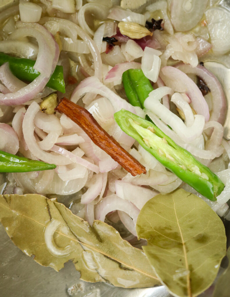 cooking onions, spices, bay leaf in a pan with some oil.