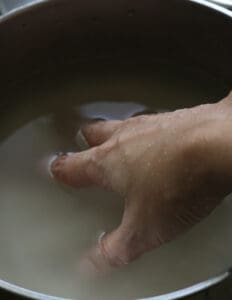 swirling water in a pan to wash the rice