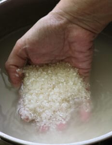 holding uncooked rice in the palm to wash