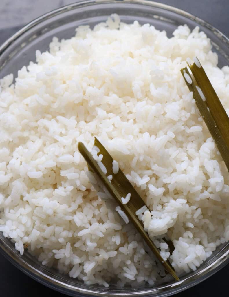 cooking rice over a stove top with pandan leaves to give fragrance.