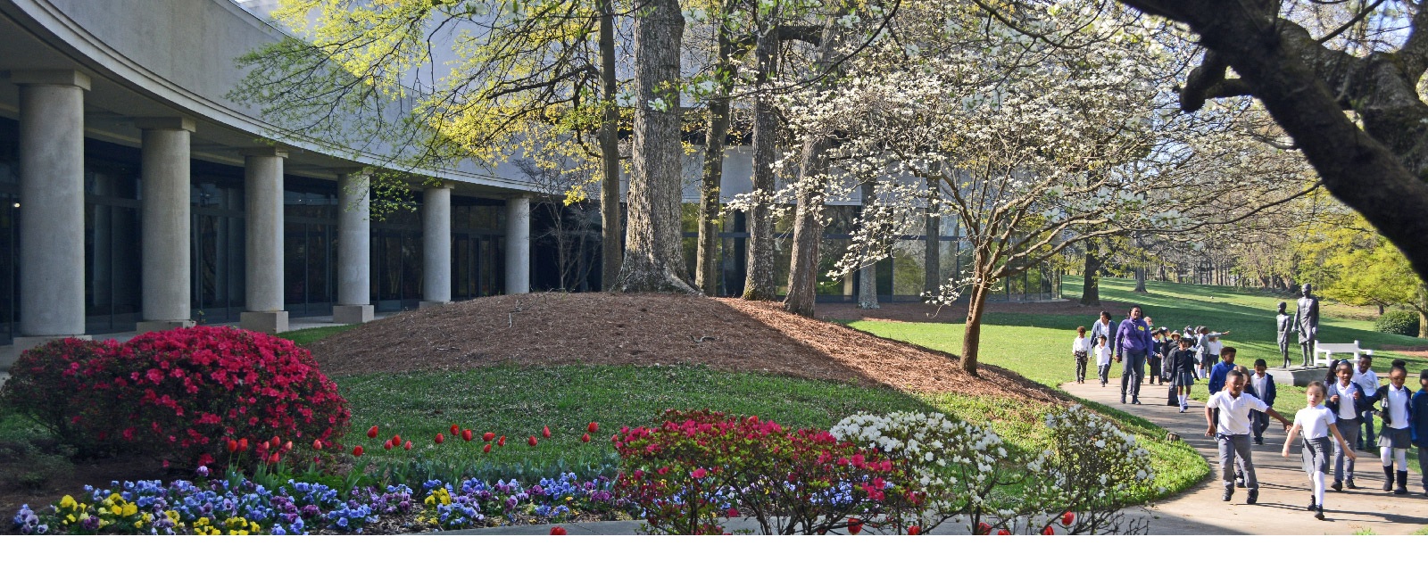 Children walk on path outside of the Carter Library