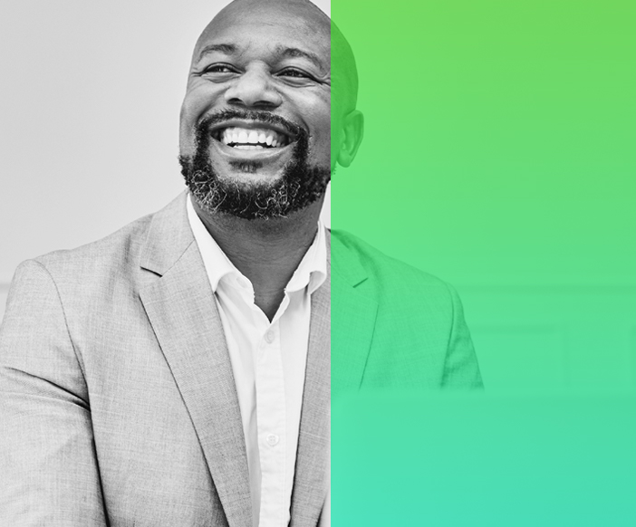 image of man with facial hair smiling wearing a suit.