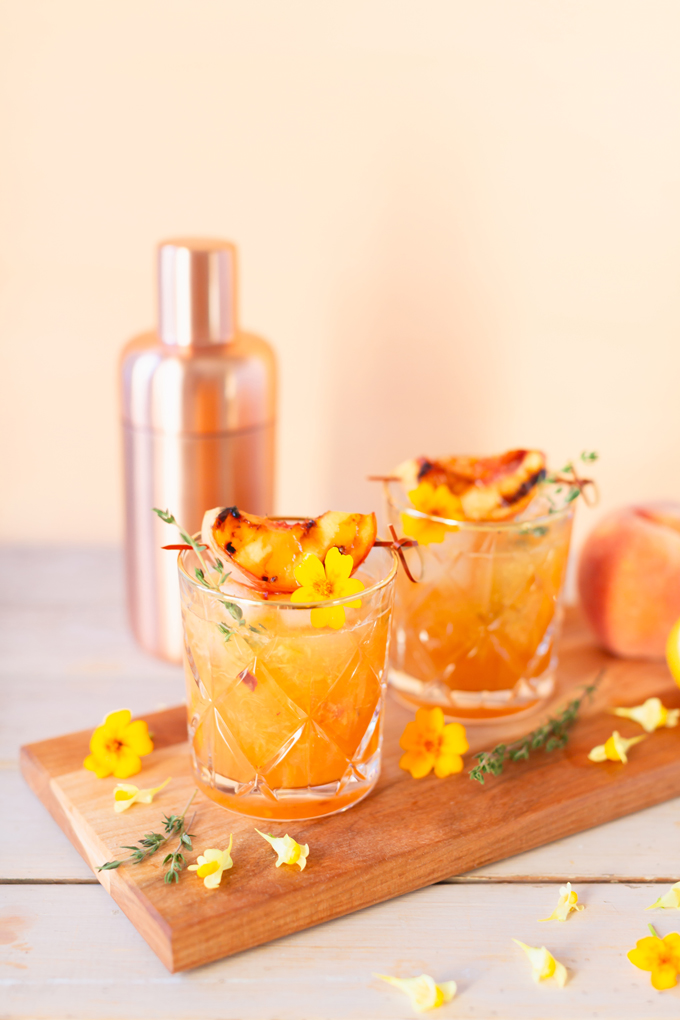 Smoked Peach Maple Bourbon Smash | A summer-meets-autumn sip juxtaposing juicy late summer fruit with a smoky grilled edge and spicy autumnal warmth | Dairy Free, Gluten Free and Refined Sugar Free -- and brimming with better-for-you ingredients! | The best fresh peach bourbon cocktail recipe | Grilled peach cocktail | Peach Bourbon Cocktail | Late summer bourbon cocktails | Southern Summer Peach Cocktail | Early Autumn Peach Cocktail | Autumn Equinox Cocktail Recipe // JustineCelina.com