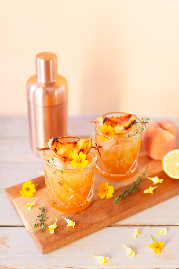 Smoked Peach Maple Bourbon Smash | A summer-meets-autumn sip juxtaposing juicy late summer fruit with a smoky grilled edge and spicy autumnal warmth | Dairy Free, Gluten Free and Refined Sugar Free -- and brimming with better-for-you ingredients! | The best fresh peach bourbon cocktail recipe | Grilled peach cocktail | Peach Bourbon Cocktail | Late summer bourbon cocktails | Southern Summer Peach Cocktail | Early Autumn Peach Cocktail | Autumn Equinox Cocktail Recipe // JustineCelina.com