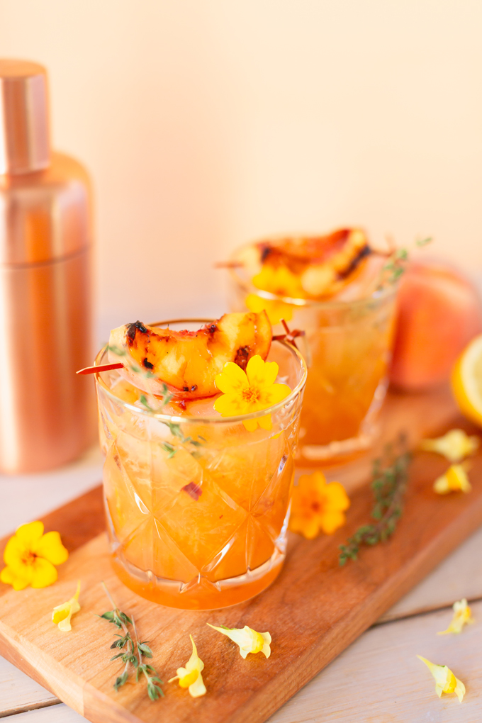 Smoked Peach Maple Bourbon Smash | A summer-meets-autumn sip juxtaposing juicy late summer fruit with a smoky grilled edge and spicy autumnal warmth | Dairy Free, Gluten Free and Refined Sugar Free -- and brimming with better-for-you ingredients! | The best fresh peach bourbon cocktail recipe | Grilled peach cocktail | Peach Bourbon Cocktail | Late summer bourbon cocktails | Southern Summer Peach Cocktail | Early Autumn Peach Cocktail | Autumn Equinox Cocktail Recipe // JustineCelina.com