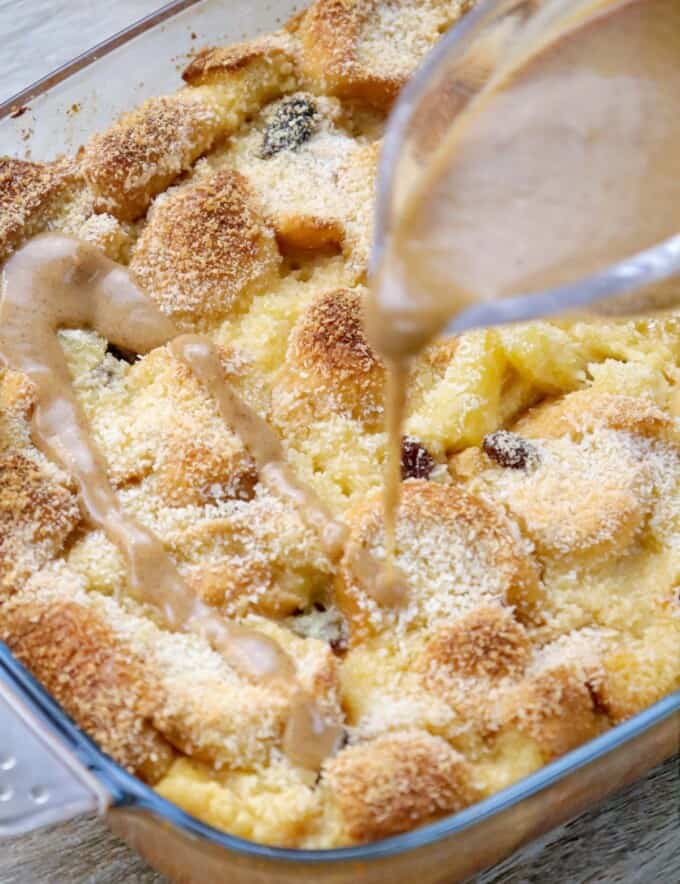 pouring caramel sauce over baked bread pudding.