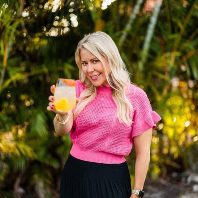 Woman holding a drink up.