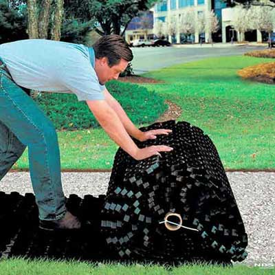 Rolled grass paver being unrolled into place