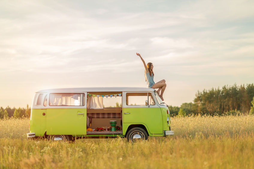 Young woman enjoying a road trip on converted bus