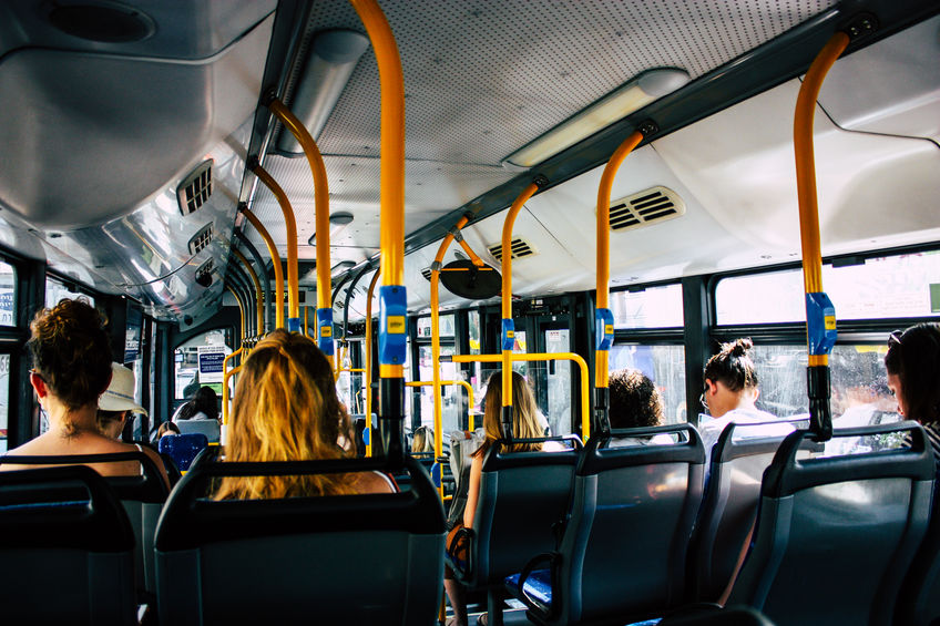 people traveling on a shuttle bus through city