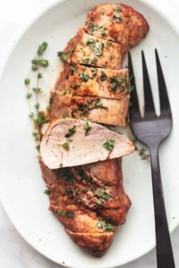 overhead sliced pork tenderloin on platter with serving fork