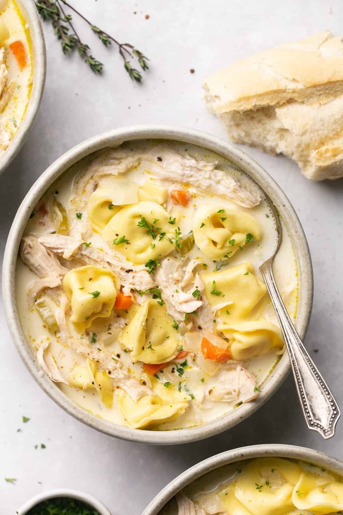 bowl of soup with veggies, chicken, and tortellini