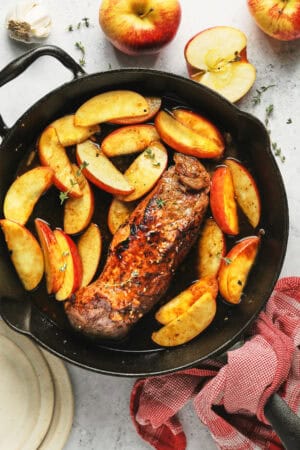 roasted pork with apples in skillet on table