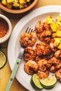 air fryer shrimp with mango salsa and fork on plate