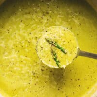 ladle scooping asparagus soup in pot