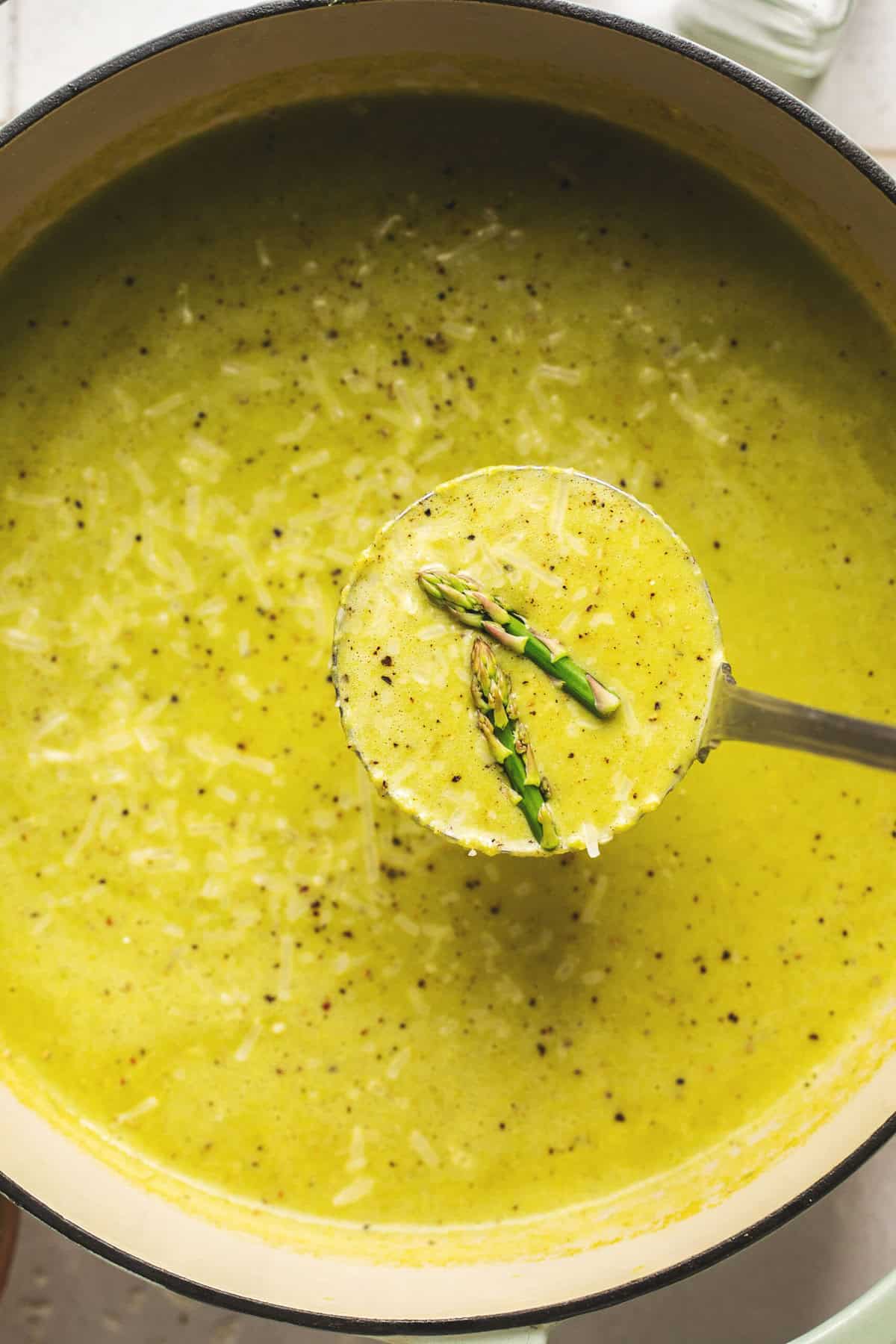 ladle scooping asparagus soup in pot