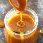 Drizzling caramel sauce into a jar full of it.