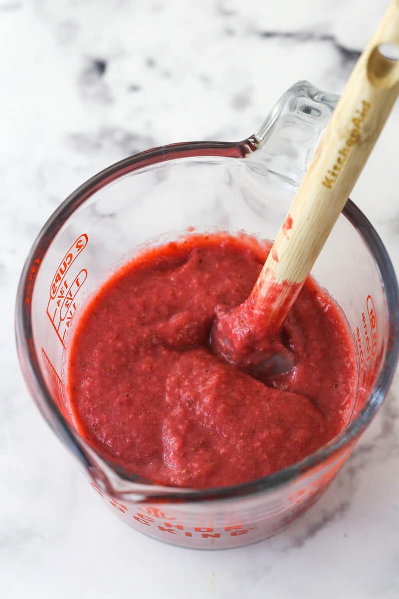 Reduced strawberry puree in a measuring cup.