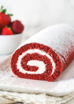 Front view of red velvet cake roll on a white platter