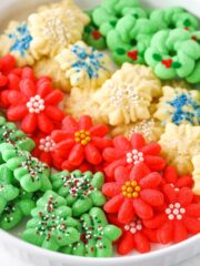 Red flower, white snowflake and green Christmas tree Spritz Cookies layered in a white cookie platter