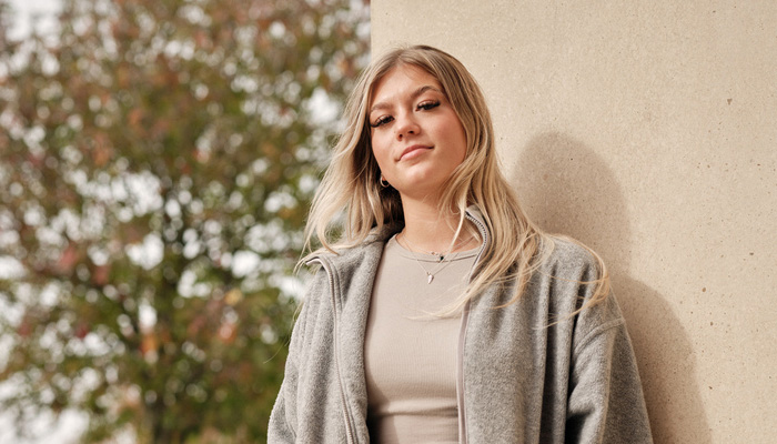 A student standing next to a wall