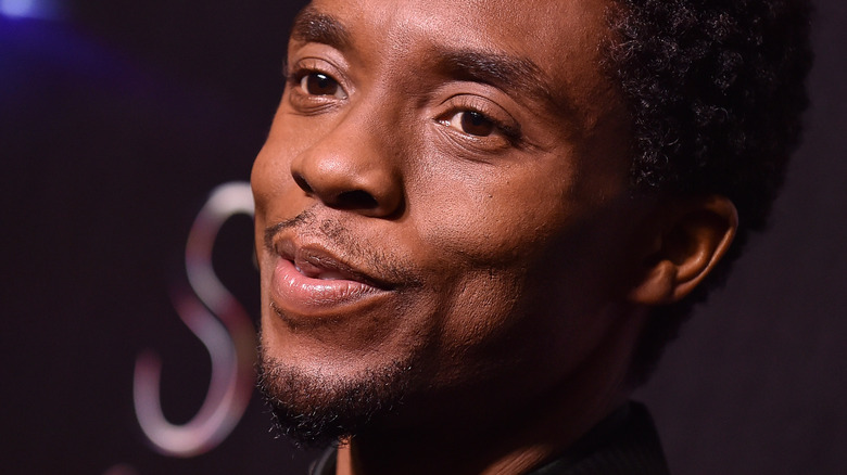 Chadwick Boseman smiling and looking off camera