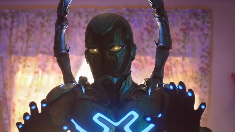 Jaime Reyes in front of the different Beetle costumes