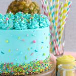 PIneapple cake with pineapple curd, teal frosting and tropical sprinkle mix