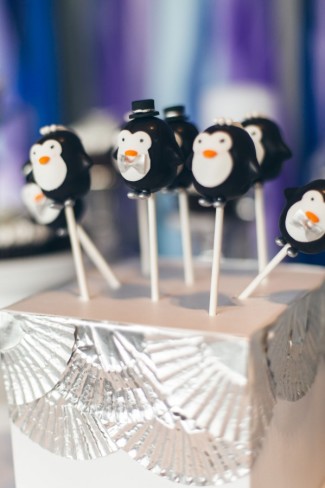 Penguin cake pops in white box decorated with silver cup cake liners 