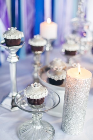 Chocolate cup cakes on small glass cake stands and candle sticks 