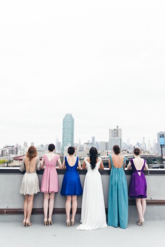 Bride with five bridesmaids wearing durga-kali dresses in pink, blue, teal, purple and grey colors 