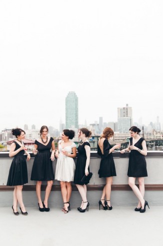 Bride wearing a white short bridal gown and bridemaids in short black dresses and high heels wearing durga-kali dresses