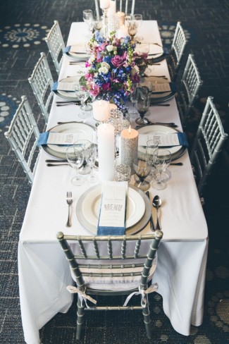 Silver and purple themed wedding reception table with silver chiavari chairs