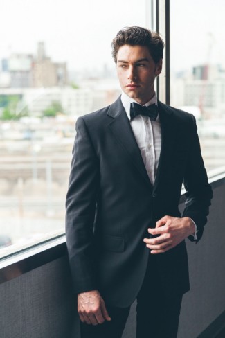 Groom in black tuxedo with black bow tie 