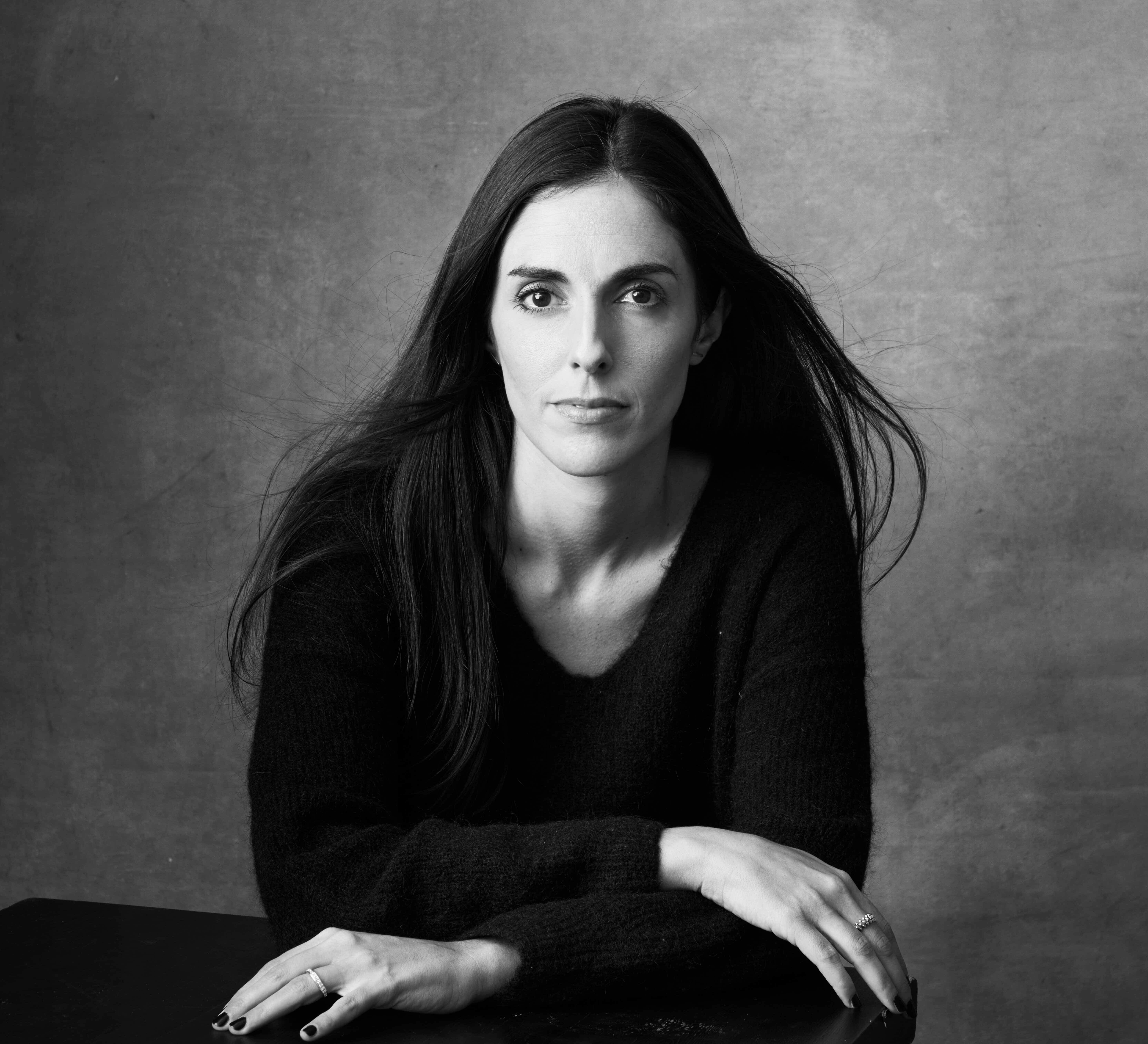 Black and white portrait of Cristina Reina, a young white woman with long, straight dark brown hair