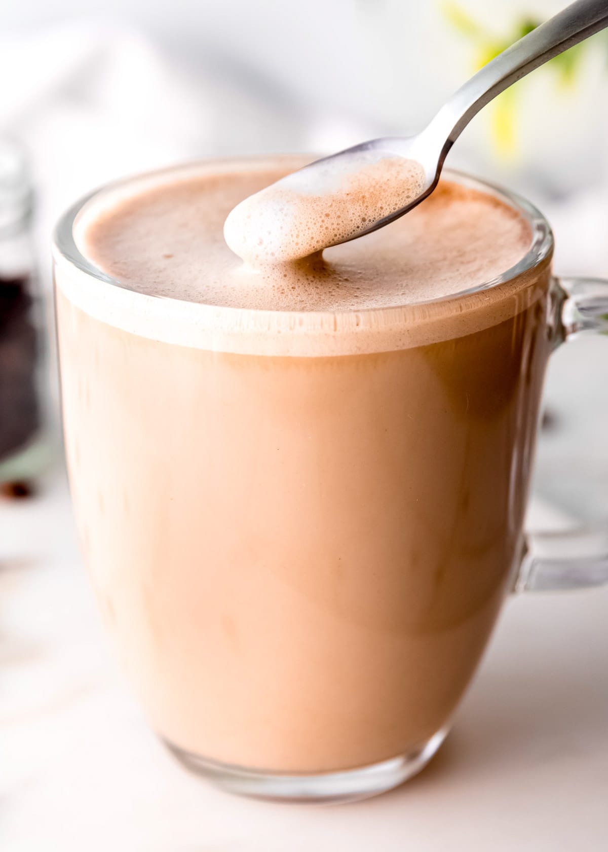 overhead image of spoonful of froth being scooped from coffee mug