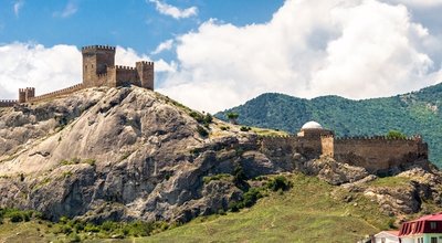 Landscape of Crimea, scenic view of old Genoese fortress in Sudak, Russia. It is landmark of Crimea. Panorama of medieval ruins at mountain top over Black Sea. Concept of summer travel in Crimea.