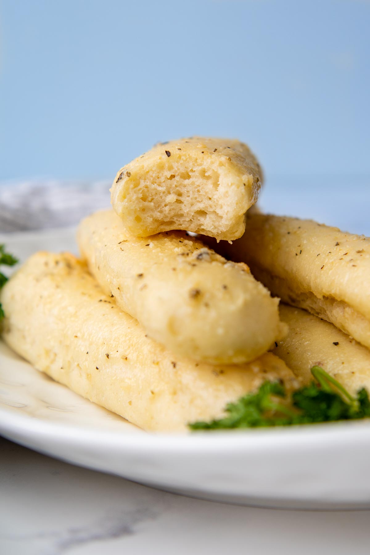 a breadstick with a bite taken out of it facing straight on