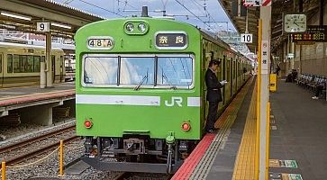 Treno locale JR, di colore verde, diretto a Nara, fermo in stazione a Kyoto.