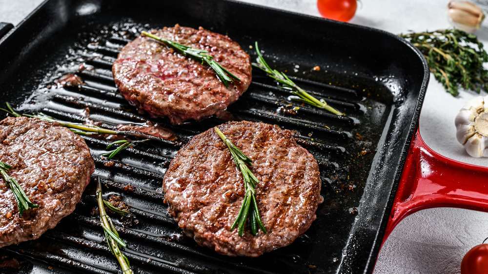 Cast iron pan with hamburgers