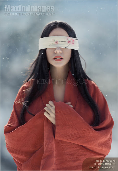 Beautiful asian woman with red sensual lips standing in the snow with a blindfold over her eyes Stock Image MXI30378 © Alex Maxim / MaximImages