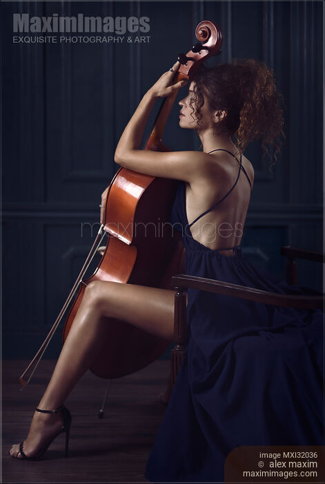 Beautiful sensual woman with a cello and a dreamy expression in elegant long dress revealing her legs and back Stock Image MXI32036 © Alex Maxim / MaximImages