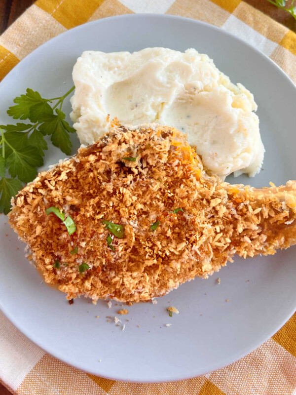 baked breaded pork chops with panko bread crumbs and mashed potatoes on plate