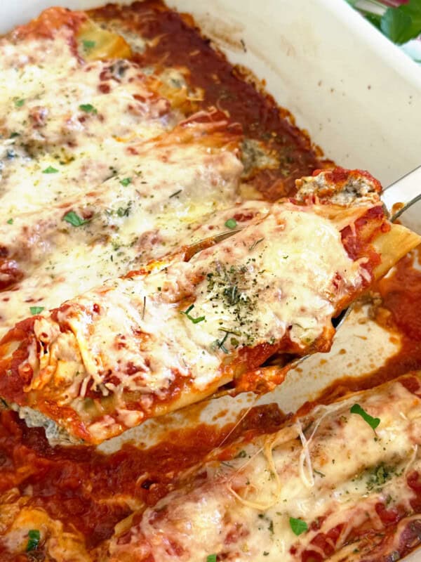 beef and cheese manicotti on a serving spoon.