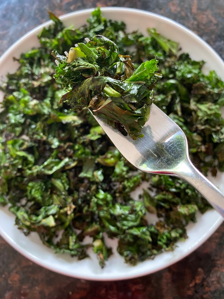 sauteed kale on a plate with fork picking some up