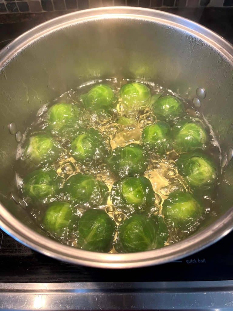 Brussel sprouts boiling in a pot of water, showing the first step in making tender yet crisp boiled Brussels sprouts.