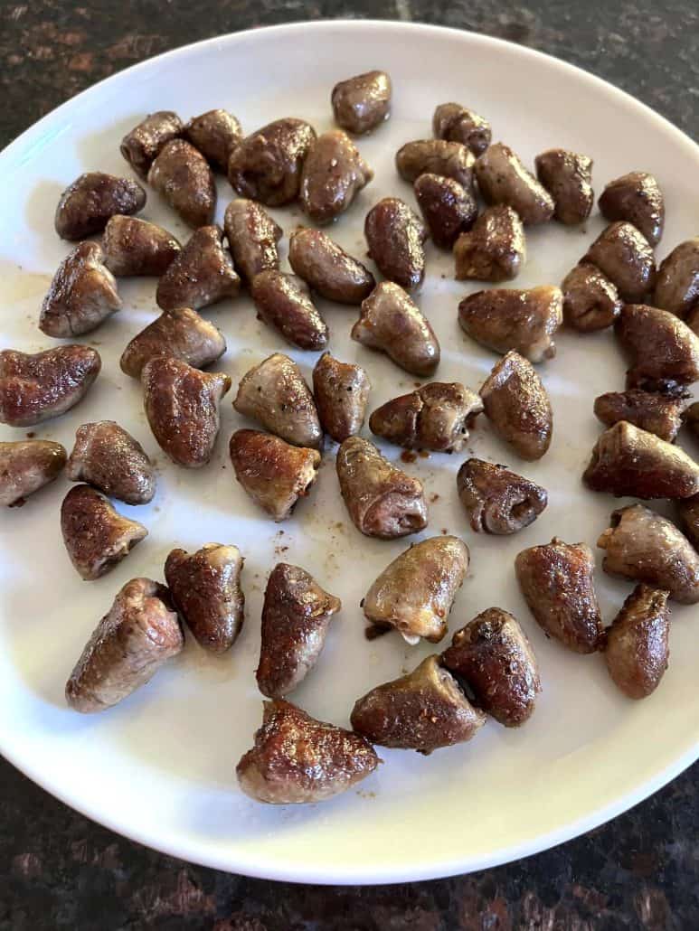 Cooked chicken hearts served on a white plate, golden-brown and ready to be enjoyed as a healthy and flavorful dish.