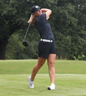 female golfer swings golf club