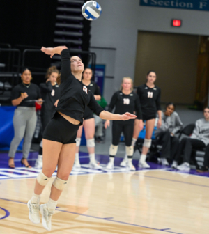 female volleyball player spikes the ball