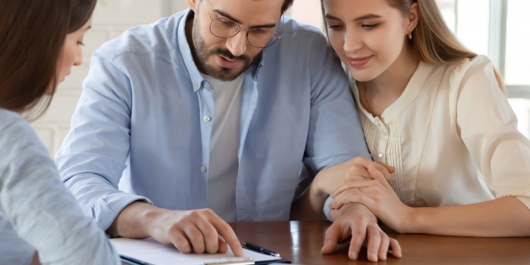 Couple talking to advisor and checking details.